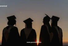 طلاب جامعيون يرتدون قبعات التخرج يقفون عند الغروب احتفالًا بنجاحهم الأكاديمي