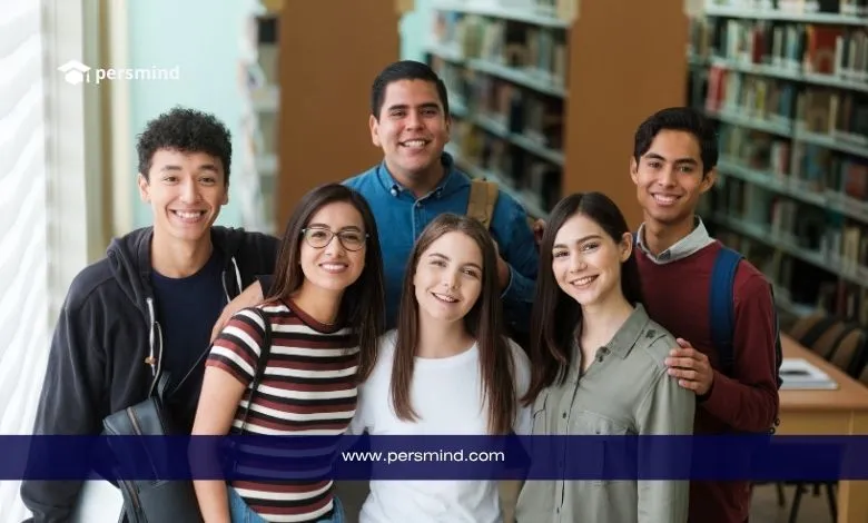 مجموعة من الطلاب الدوليين يبتسمون داخل مكتبة جامعية