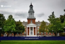 مبنى جامعة هارفارد التاريخي وسط أشجار خضراء يرمز إلى الدورات المجانية عبر الإنترنت