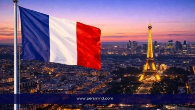 علم فرنسا يرفرف فوق مدينة باريس مع إطلالة على برج إيفل مضاء عند الغروب – صورة مرافقة لمقال المنتدى العالمي للديمقراطية في فرنسا.