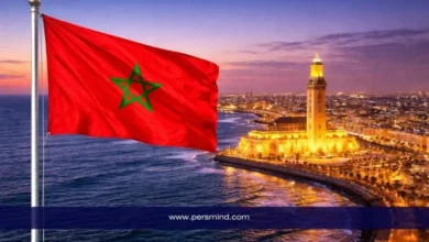 علم المغرب يرفرف فوق مدينة الدار البيضاء مع إطلالة على مسجد الحسن الثاني عند الغروب – صورة مرافقة لمقال مؤتمر الشباب في المغرب.