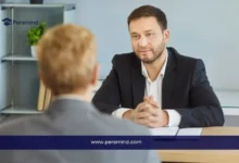 رجل يجري مقابلة مع طالب في أجواء رسمية، صورة تعبّر عن أسئلة مقابلات المنح الدراسية والتحضير للإجابات النموذجية.