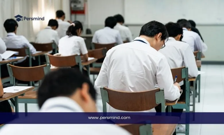 طلاب في قاعة امتحان رسمية يؤدون اختبارًا كتابيًا، صورة تعبر عن اختبار GMAT Focus للقبول في ماجستير إدارة الأعمال.