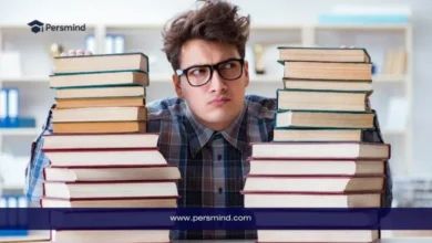 طالب يجلس بين مجموعة كبيرة من الكتب، صورة تعبّر عن التحضير لاختبار GMAT Focus للقبول في ماجستير إدارة الأعمال.