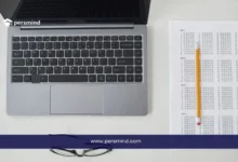 لابتوب بجانبه ورقة اختبار متعددة الخيارات مع قلم رصاص، صورة تعبر عن الاستعداد لاختبار SAT الرقمي للقبول الجامعي.