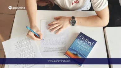 طالب يكتب على ورقة امتحان وبجانبه قاموس أكسفورد، صورة تعبّر عن الاستعداد لاختبار TOEFL iBT لقياس مهارات اللغة الإنجليزية الأكاديمية.