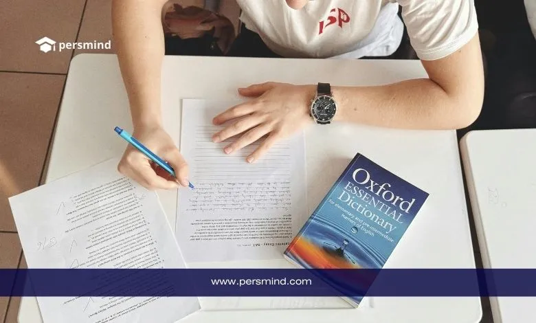 طالب يكتب على ورقة امتحان وبجانبه قاموس أكسفورد، صورة تعبّر عن الاستعداد لاختبار TOEFL iBT لقياس مهارات اللغة الإنجليزية الأكاديمية.