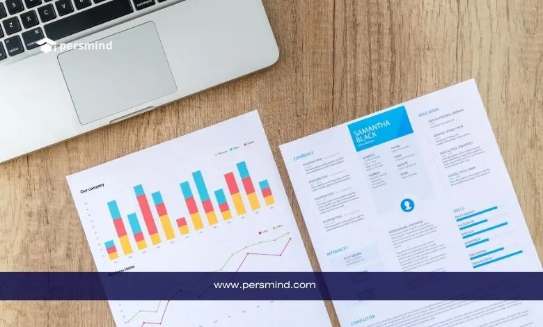 أوراق مطبوعة بجانب لابتوب، تضم سيرة ذاتية أكاديمية ورسوم بيانية، تعبير عن إعداد CV احترافي للمنح الدراسية والجامعات.