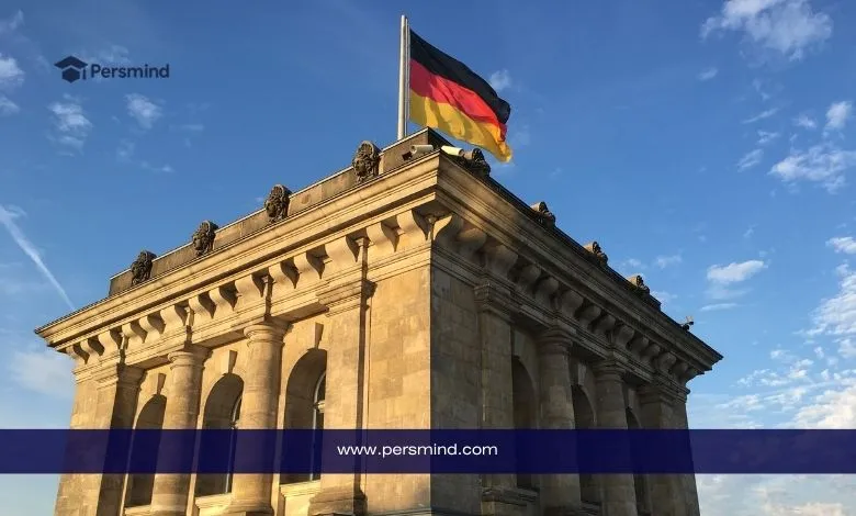 العلم الألماني فوق مبنى تاريخي في برلين عند الغروب، صورة تعبّر عن منح DAAD الممولة بالكامل للطلاب الدوليين في ألمانيا.