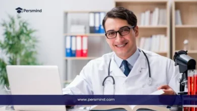 طبيب مبتسم يجلس أمام حاسوبه في مكتبه يمثل فرص منح لدراسة الطب بدون ايلتس لعام 2025