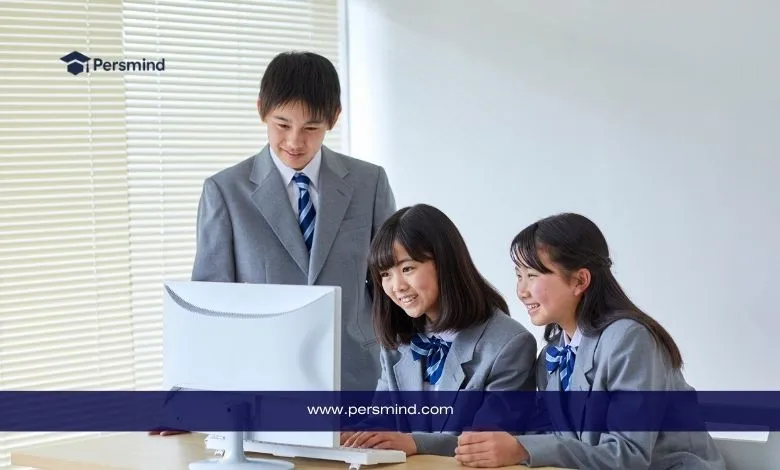ثلاثة طلاب يابانيين يرتدون زيًا مدرسيًا رسميًا ويعملون معًا أمام شاشة حاسوب في فصل دراسي مضاء بضوء النهار، مع شعار Persmind في الزاوية العليا.