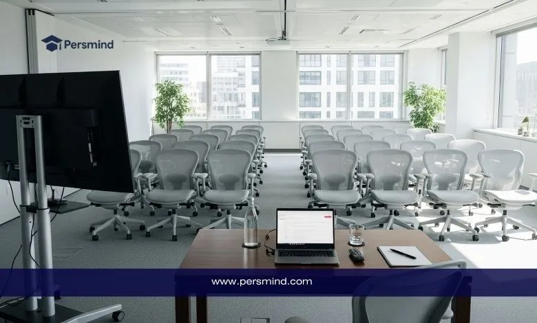 قاعة اجتماعات مجهّزة بمقاعد حديثة وشاشة عرض، مع مكتب يحتوي على لابتوب يحمل هوية منصة Persmind.