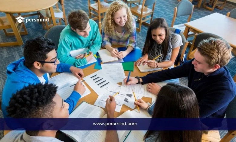 مجموعة طلاب دوليين يدرسون معًا داخل مكتبة جامعية – صورة تعبّر عن فرص المنح الدراسية في بريطانيا