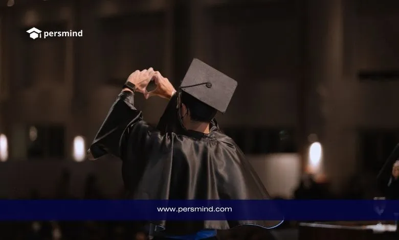 طالب يرتدي زي التخرج ويصنع علامة قلب بيديه خلال حفل تخرّج – صورة تعبّر عن النجاح وفرص المنح الدراسية