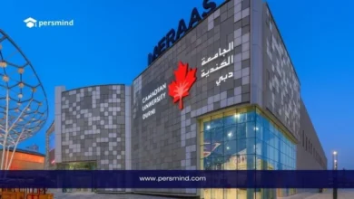 منحة الجامعة الكندية في دبي مع شعار Persmind في الأعلى ومبنى Meraas العصري في الخلفية خلال المساء.