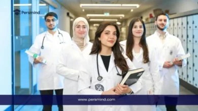 مجموعة من الطلاب الدوليين يرتدون المعاطف الطبية داخل جامعة حديثة، في مشهد يعكس فرص الدراسة في فرنسا بدون IELTS