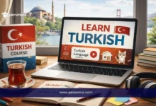 حاسوب محمول يعرض عبارة LEARN TURKISH مع كتاب Turkish Course وشاي تركي على المكتب، في صورة تعبيرية لمقال دورة تعلم اللغة التركية عبر الإنترنت.