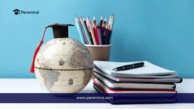 كرة أرضية صغيرة عليها قبعة تخرج بجانب دفاتر وأقلام للدلالة على منح جامعة ساسكاتشوان للطلاب الدوليين.