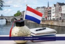 صورة لعلم هولندا مع مجسم للكرة الأرضية يرتدي قبعة تخرج وكتب دراسية في مدينة ماستريخت، تُستخدم للتعبير عن منح جامعة ماستريخت للطلاب الدوليين.