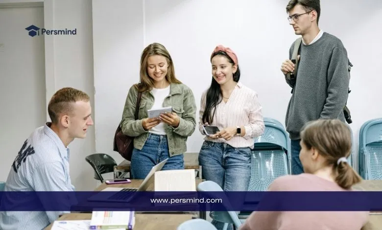 طلاب جامعيون يتفاعلون داخل قاعة دراسية أثناء مناقشة أوراق التقديم والمنح الدراسية، مع أجواء تعلّم تعاونية.