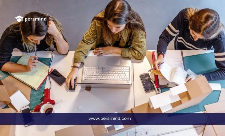 طالبات يعملن على مشروع أكاديمي باستخدام الكمبيوتر وأدوات التصميم داخل بيئة جامعية.