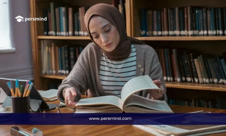 طالبة تدرس في مكتبة جامعية ضمن منحة جامعة هلسنكي وهي تقرأ كتابًا كبيرًا على طاولة خشبية.