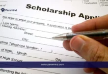 صورة طالب يملأ نموذج طلب منحة دراسية باستخدام قلم أثناء التحضير للحصول على خطاب توصية قوي