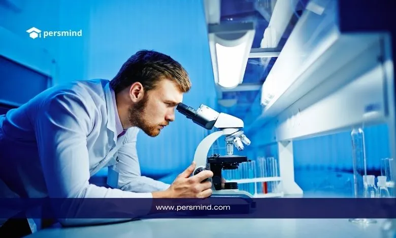 عالم أحياء دقيقة يفحص عينة باستخدام المجهر داخل مختبر متخصص، في سياق دراسة علم الأحياء الدقيقة والبحوث الميكروبية.