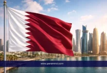 علم قطر مرفوع أمام أفق مدينة الدوحة مع الأبراج الحديثة، يرمز إلى فرص العمل والعقود الوظيفية في قطر.