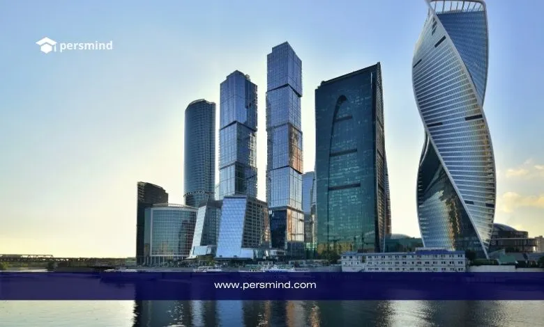 صورة لأبراج مدينة موسكو الحديثة تنعكس على نهر موسكفا عند الغروب، مع شعار Persmind ورابط الموقع في الأسفل، تُستخدم في مقال فرصة عمل دولية في روسيا.