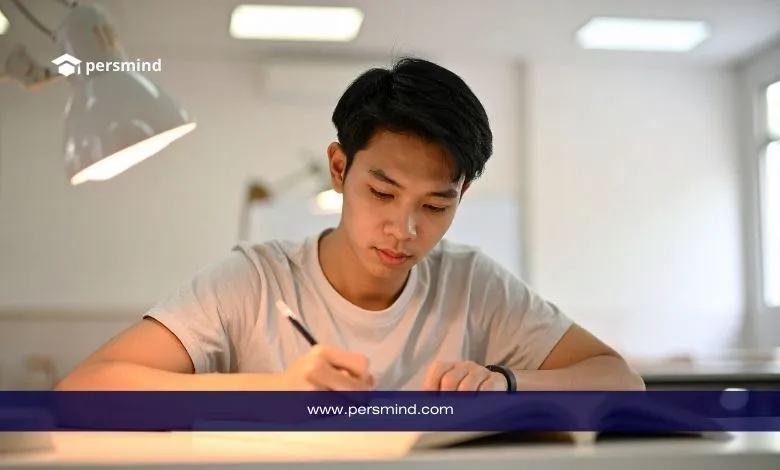 طالب جامعي يجلس على مكتب داخل قاعة دراسة ويكتب في دفتره، مع وجود شعار Persmind أعلى الصورة.