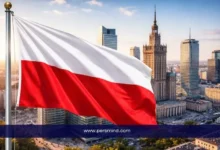 علم بولندا يرفرف أمام أفق مدينة وارسو يرمز إلى منحة Polonista NAWA للدراسة في بولندا
