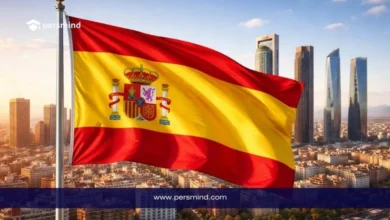 علم إسبانيا يرفرف أمام أفق مدينة حديثة يرمز إلى منحة جامعة خايين في إسبانيا