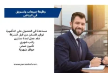 رجل أعمال يجلس في مكتب حديث ويرتدي بدلة رسمية، مع لوحة معلومات تلخص مزايا وظيفة مبيعات وتسويق في الرياض.