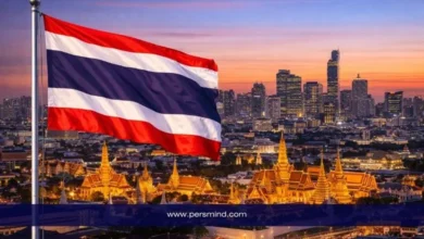 علم تايلاند يرفرف فوق مدينة بانكوك مع إطلالة على القصر الملكي وأفق المدينة عند الغروب – صورة مرافقة لمقال برنامج القيادة الدولي في تايلاند 2026.