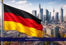 علم ألمانيا أمام أفق مدينة ألمانية حديثة في إشارة إلى زمالة أينشتاين في ألمانيا للباحثين الشباب