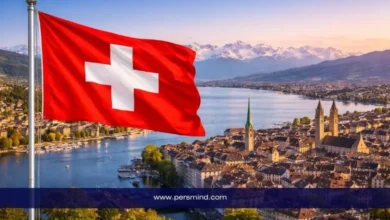 علم سويسرا يرفرف فوق مدينة سويسرية بإطلالة على البحيرة والجبال – صورة لمقال زمالة الصندوق الإنساني التابعة للمفوضية السامية لحقوق الإنسان.