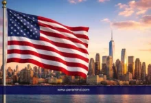 علم الولايات المتحدة أمام أفق مدينة نيويورك ضمن مقال عن زمالة ستيرن بجامعة نيويورك