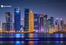 أفق مدينة الدوحة في قطر ليلًا مع ناطحات السحاب المضيئة وانعكاس الأضواء على المياه لمقال عن فرصة عمل في قطر