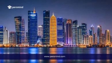 أفق مدينة الدوحة في قطر ليلًا مع ناطحات السحاب المضيئة وانعكاس الأضواء على المياه لمقال عن فرصة عمل في قطر