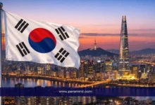 علم كوريا الجنوبية يرفرف أمام أفق مدينة سيول مع برج لوتيه ونهر الهان عند الغروب – صورة مرافقة لمقال منتدى اليونسكو للتراث العالمي 2026.