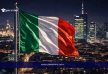 علم إيطاليا أمام أفق مدينة ميلانو ليلًا ضمن مقال عن منحة الحكومة الإيطالية MAECI للطلاب الدوليين
