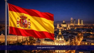 علم إسبانيا أمام أفق مدينة مدريد ليلًا ضمن مقال عن منحة جامعة مدريد المستقلة وشروط التقديم