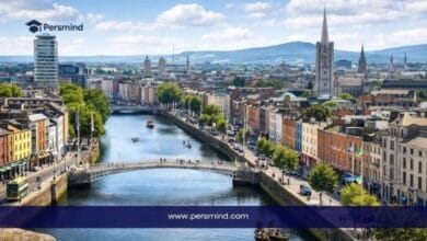 Daytime image of Dublin, Ireland, showing the River Liffey, a central bridge, and surrounding city buildings for the John Thompson Scholarship in Ireland article.