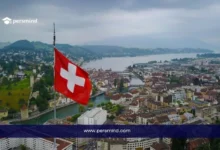 صورة لعلم سويسرا يطل على مدينة سويسرية جميلة، تعبر عن برنامج سيرن للطلاب في سويسرا