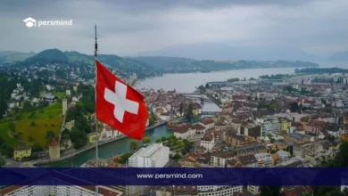 صورة لعلم سويسرا يطل على مدينة سويسرية جميلة، تعبر عن برنامج سيرن للطلاب في سويسرا