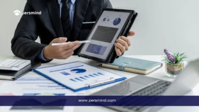 مدير أعمال يعرض تقارير ورسومًا بيانية على جهاز لوحي فوق مكتب عمل، في صورة تعبر عن وظيفة رئيس قسم المشتريات والتخطيط