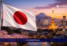 علم اليابان مع خلفية مدينة يابانية عند الغروب وبرج مضيء وجبل فوجي في صورة لمقال قمة شباب اليابان في أوساكا.