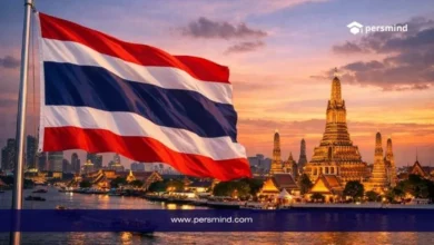 علم تايلاند مع خلفية لمعالم مدينة بانكوك وقت الغروب في صورة لمقال قمة عقول المستقبل في تايلاند.