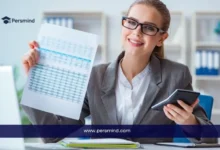 مدققة حسابات مبتسمة ترتدي نظارات وتمسك بجدول بيانات مالي وآلة حاسبة في مكتب، ترويجاً لوظيفة مدقق حسابات براتب ومزايا قوية عبر Persmind.